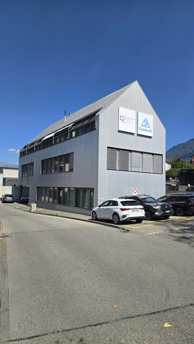 Fassade mit FactorAI-Logo und Parkplatz